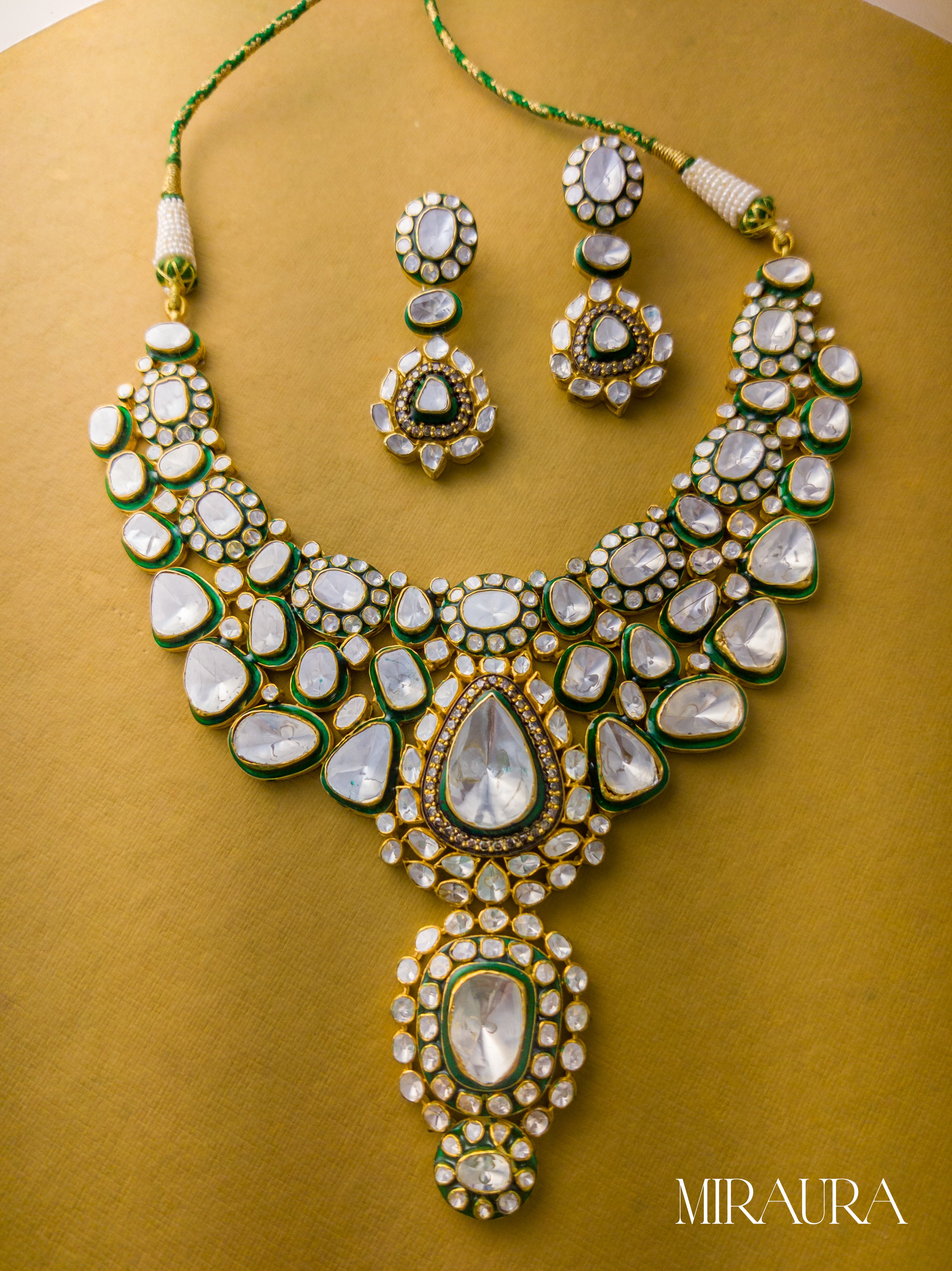 Ornate necklace set with green and gold accents on a yellow background